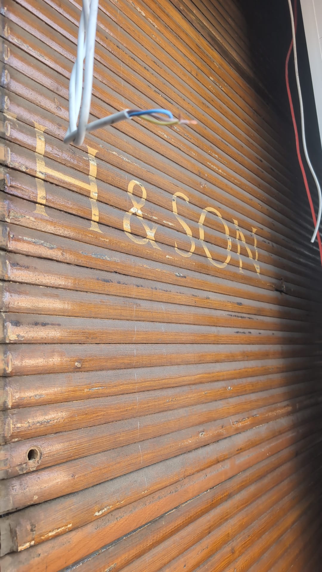 Gold lettering reading '& Son' on the original wooden blinds